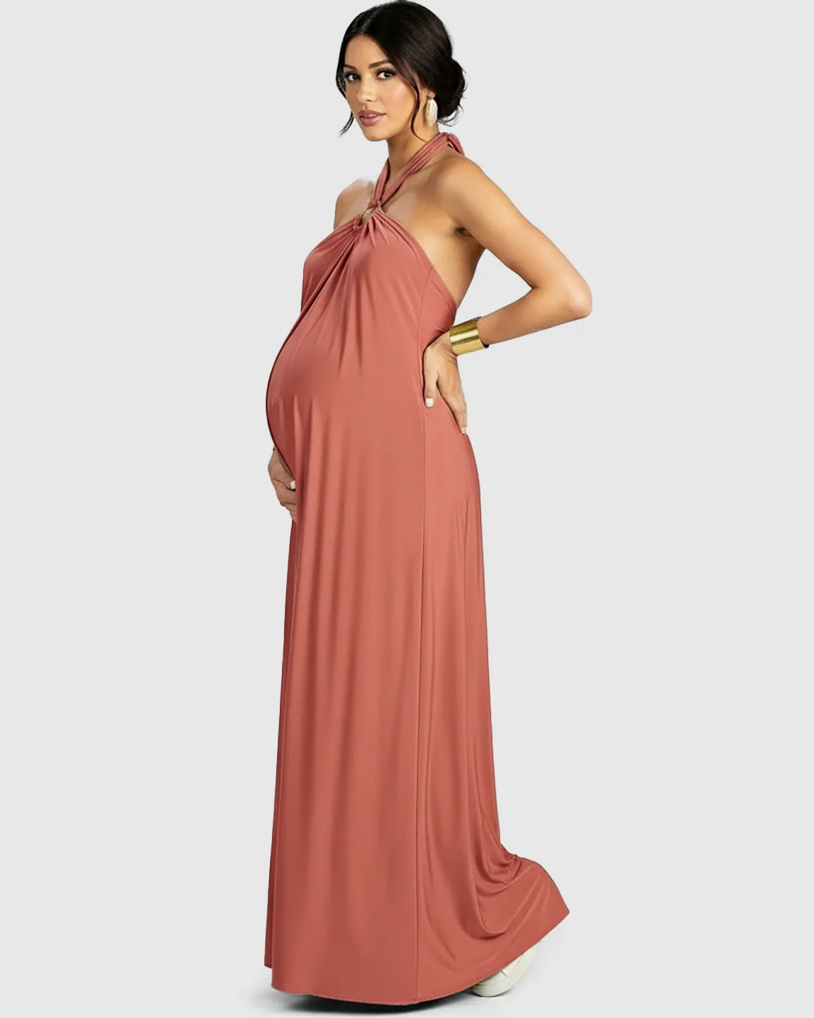 Maternity model in a terracotta backless halter neck chiffon maxi dress, showcasing a comfortable, flowing fit.