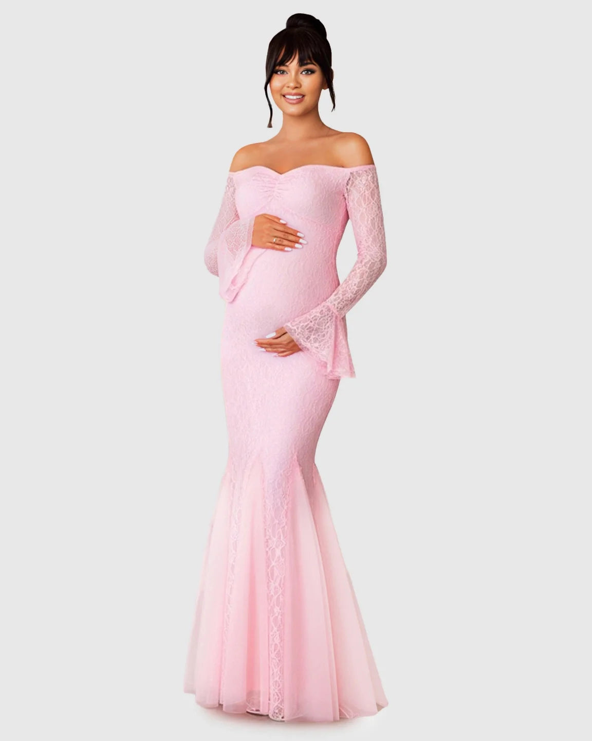 Smiling pregnant woman in a pink off-shoulder lace mermaid maternity maxi dress with bell sleeves.