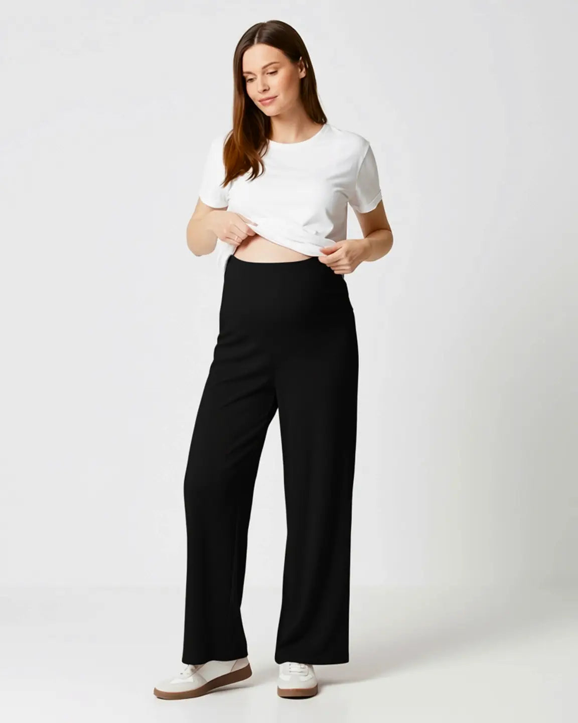 Woman in black wide-leg stretch maternity pants with over-bump waistband and white t-shirt.
