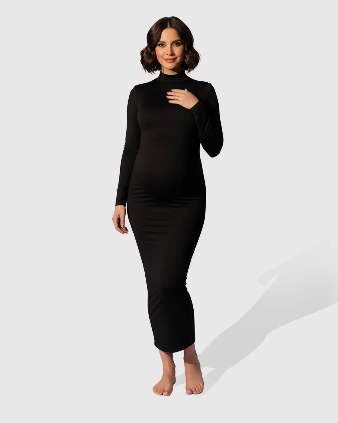 Smiling pregnant woman in a black mock-neck bodycon maternity maxi dress, long sleeves, fitted silhouette.