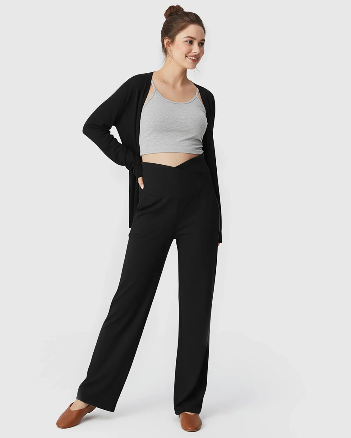 Woman in black crossover waist wide-leg maternity lounge pants, grey crop top, and black cardigan.