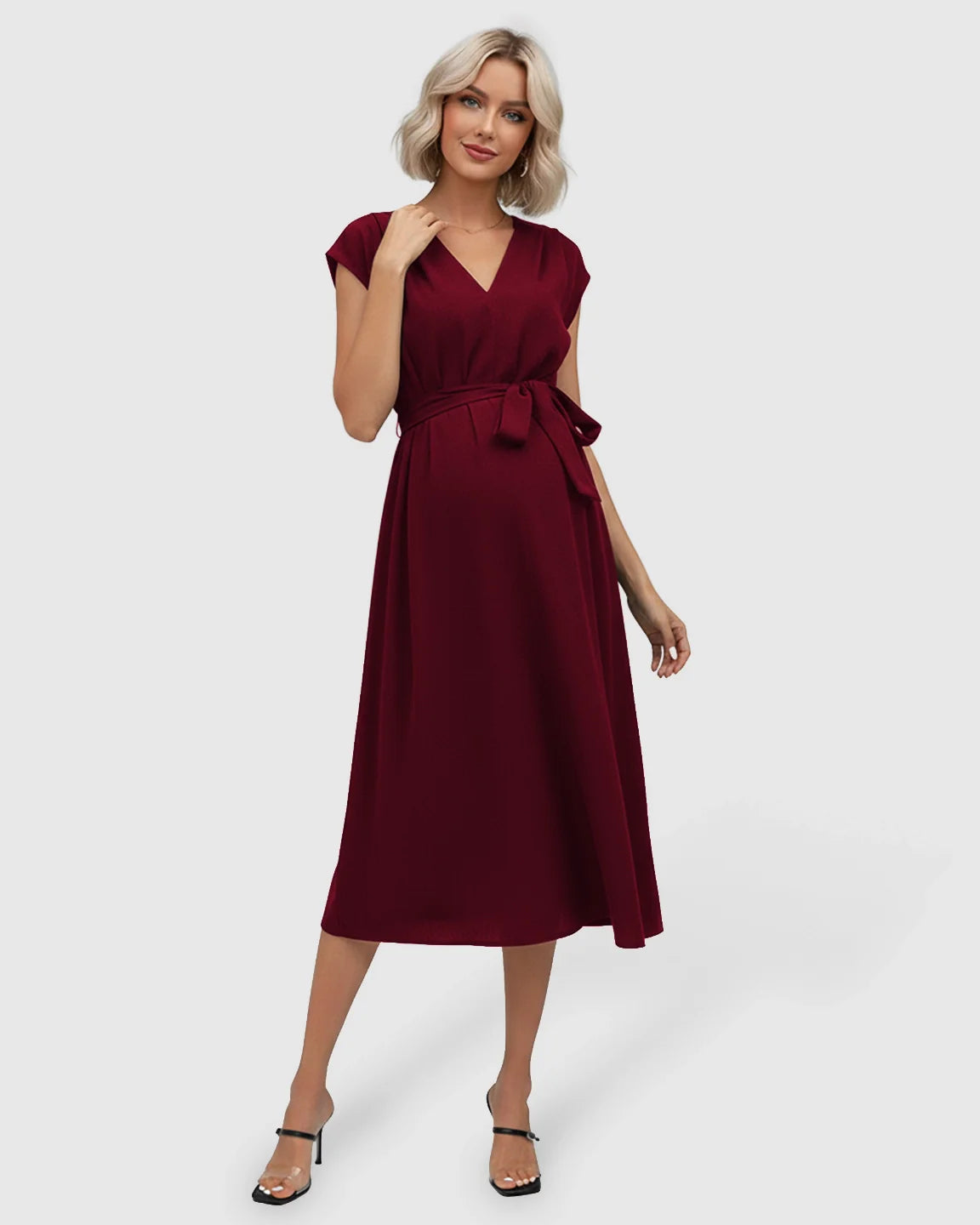 Red tie-waist V-neck maternity midi dress with flutter sleeves, worn by a smiling blonde woman.