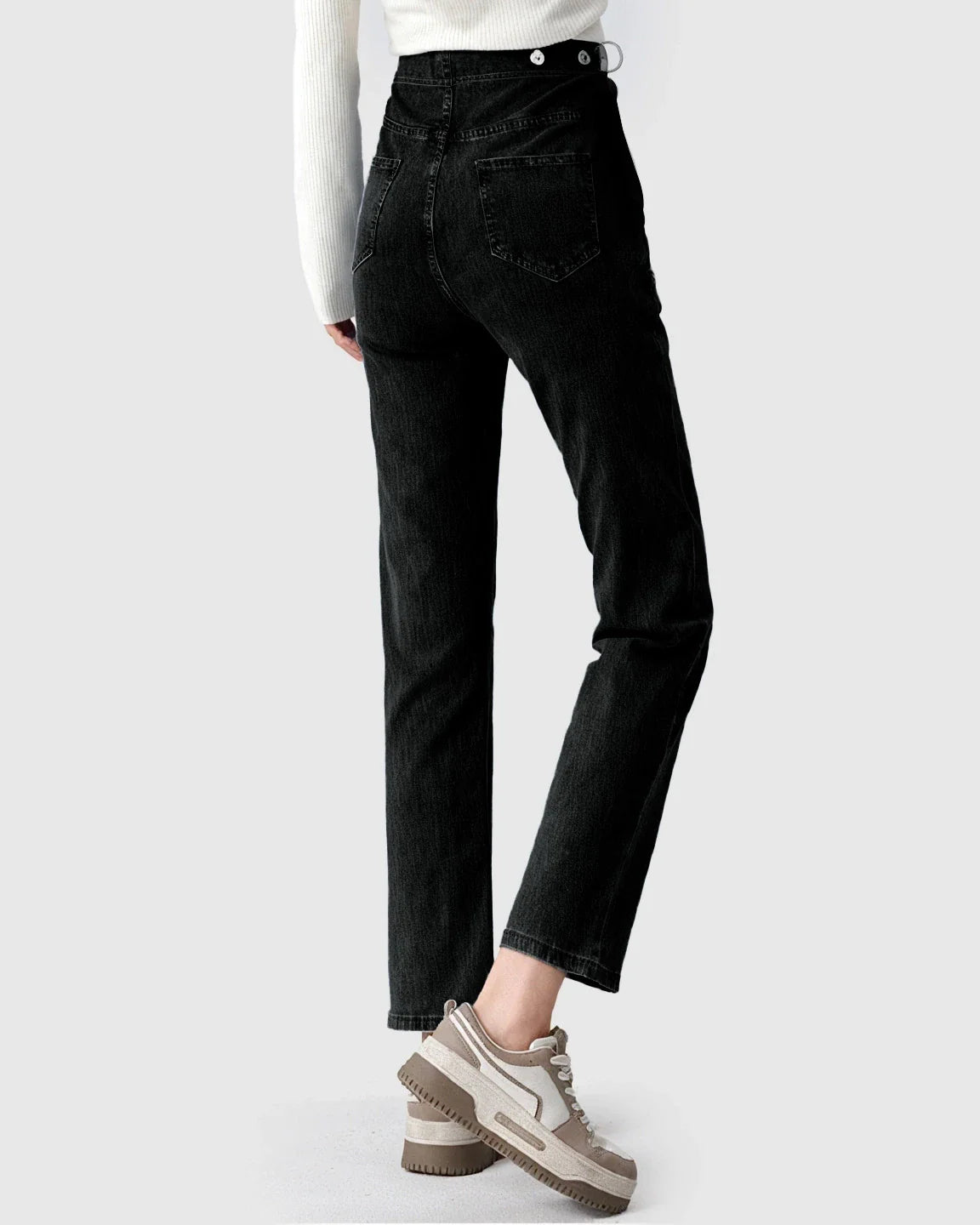 Black stretch denim straight-leg maternity jeans with high waist and button details, worn with sneakers.
