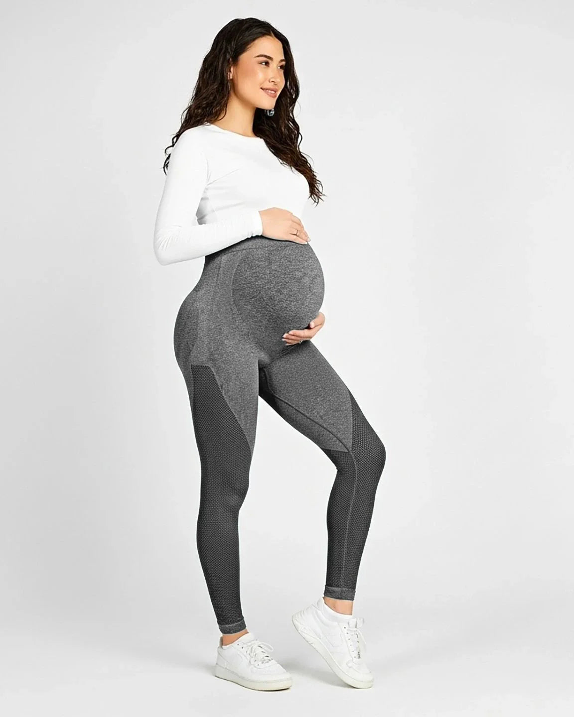 Smiling pregnant woman in gray high-elastic, body-hugging maternity leggings with textured panels.