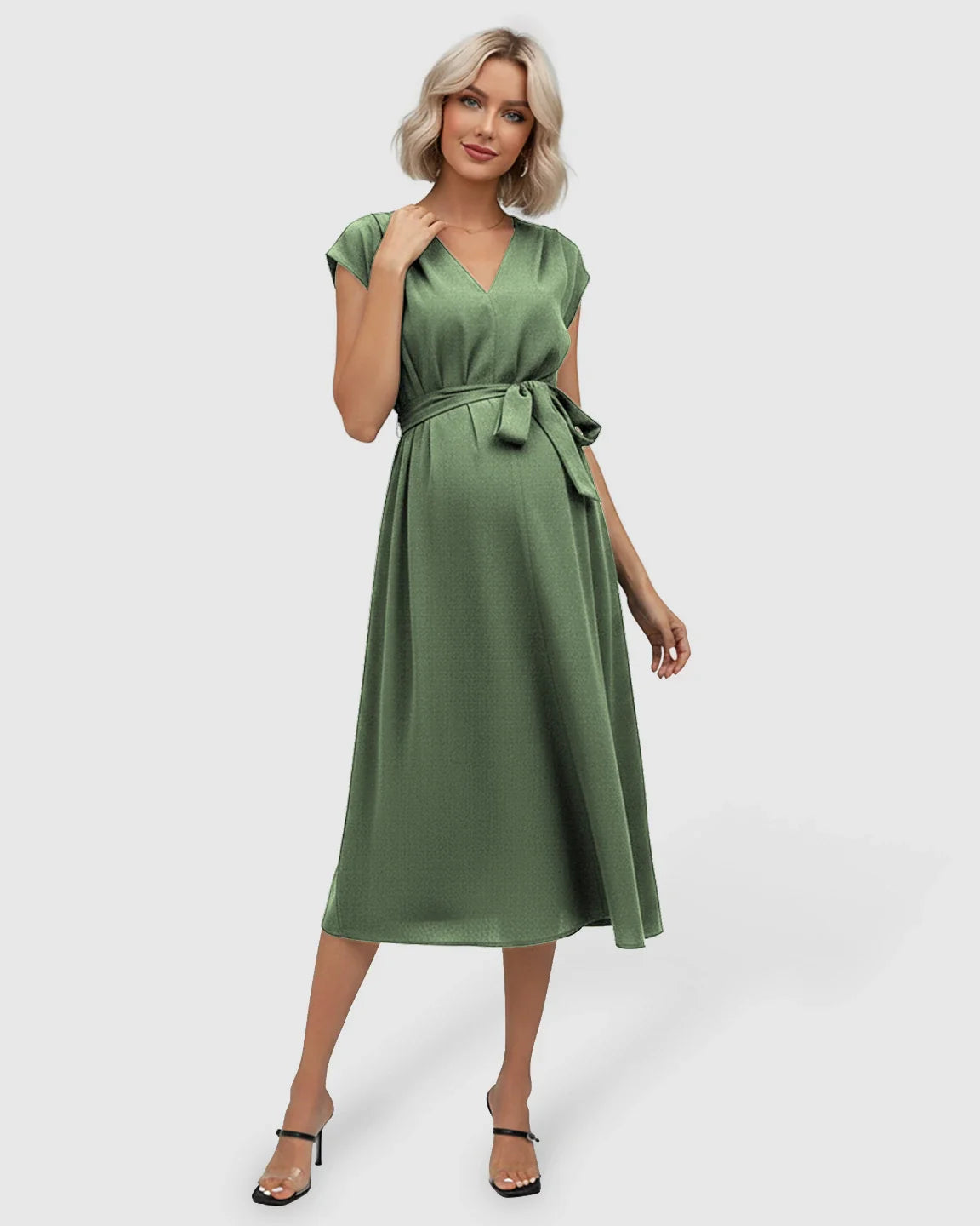 Blonde pregnant model in a green tie-waist V-neck maternity midi dress with flutter sleeves.