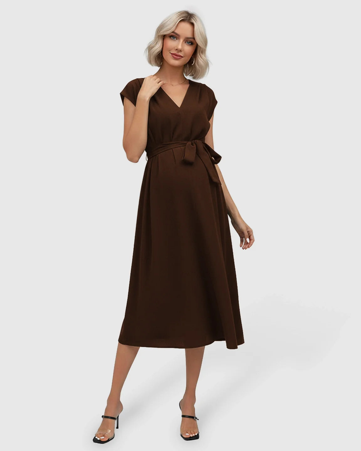 Blonde model in a brown V-neck maternity midi dress with flutter sleeves and an adjustable tie-waist.