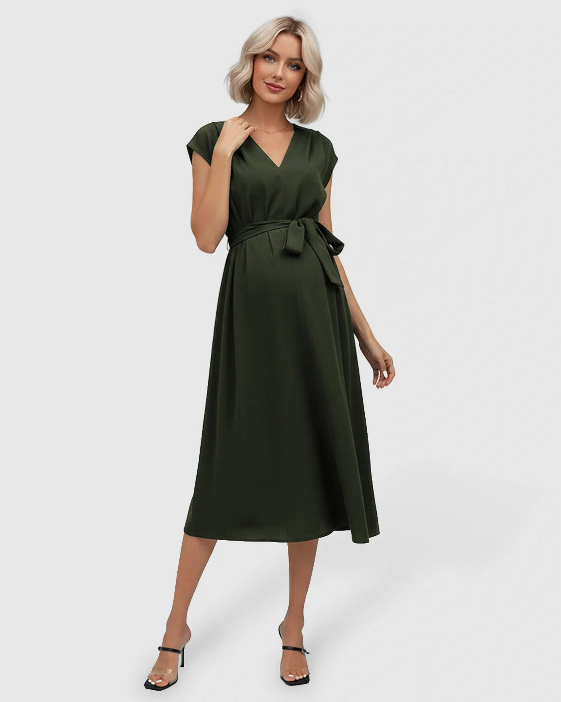 Blonde pregnant model in a dark green tie-waist V-neck maternity midi dress with flutter sleeves.