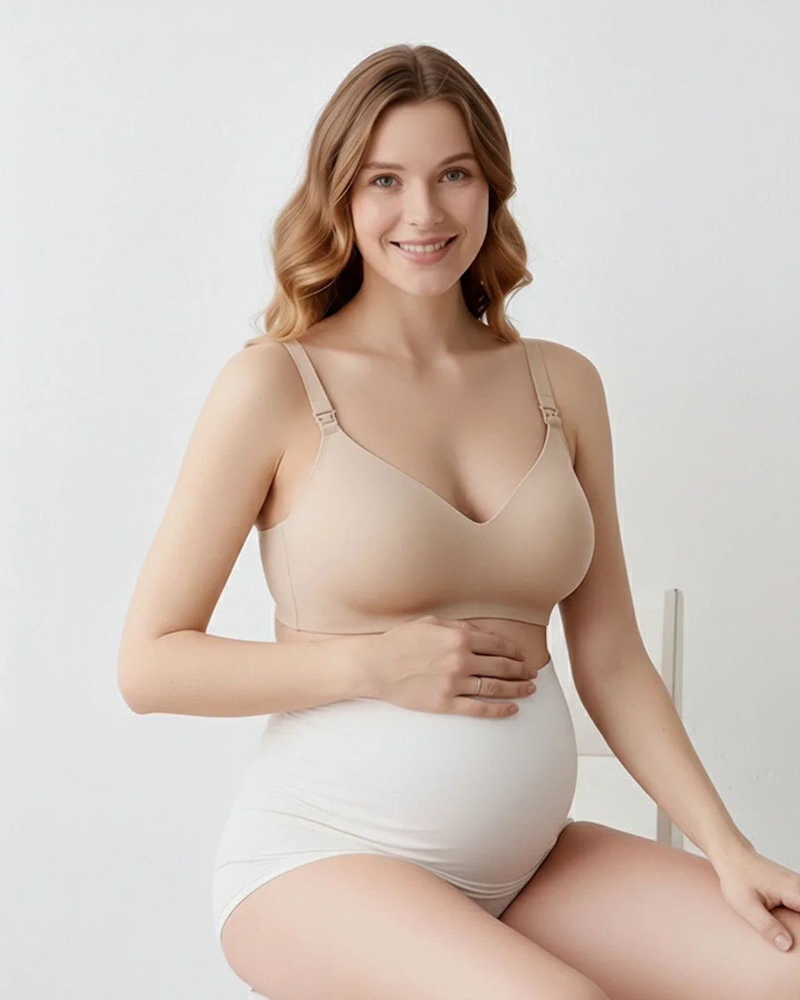 Smiling pregnant woman in a nude seamless maternity bra and white full-coverage briefs.