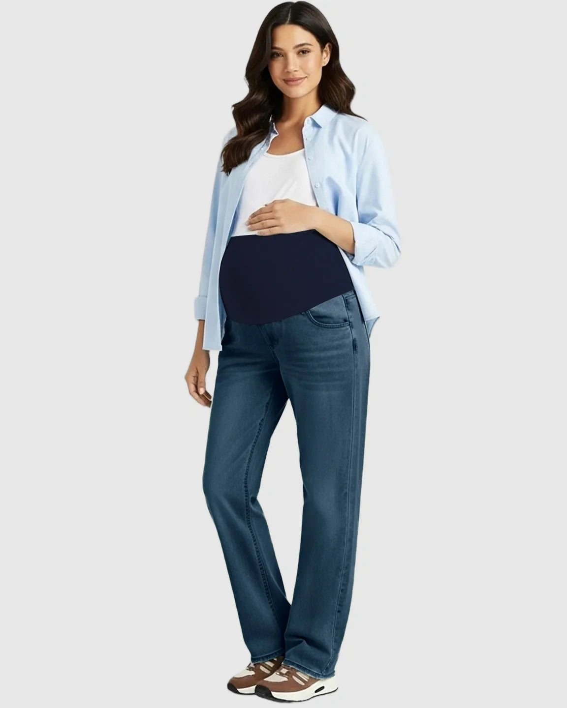 Woman in blue straight-leg maternity jeans with a navy belly band, white tank, and light blue shirt.