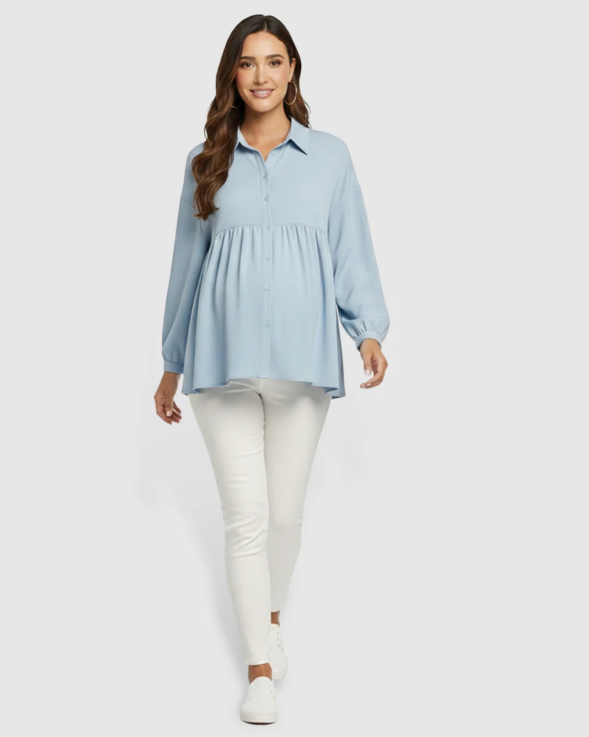 Smiling pregnant woman in a light blue chiffon maternity shirt with lapel collar and button-down front.