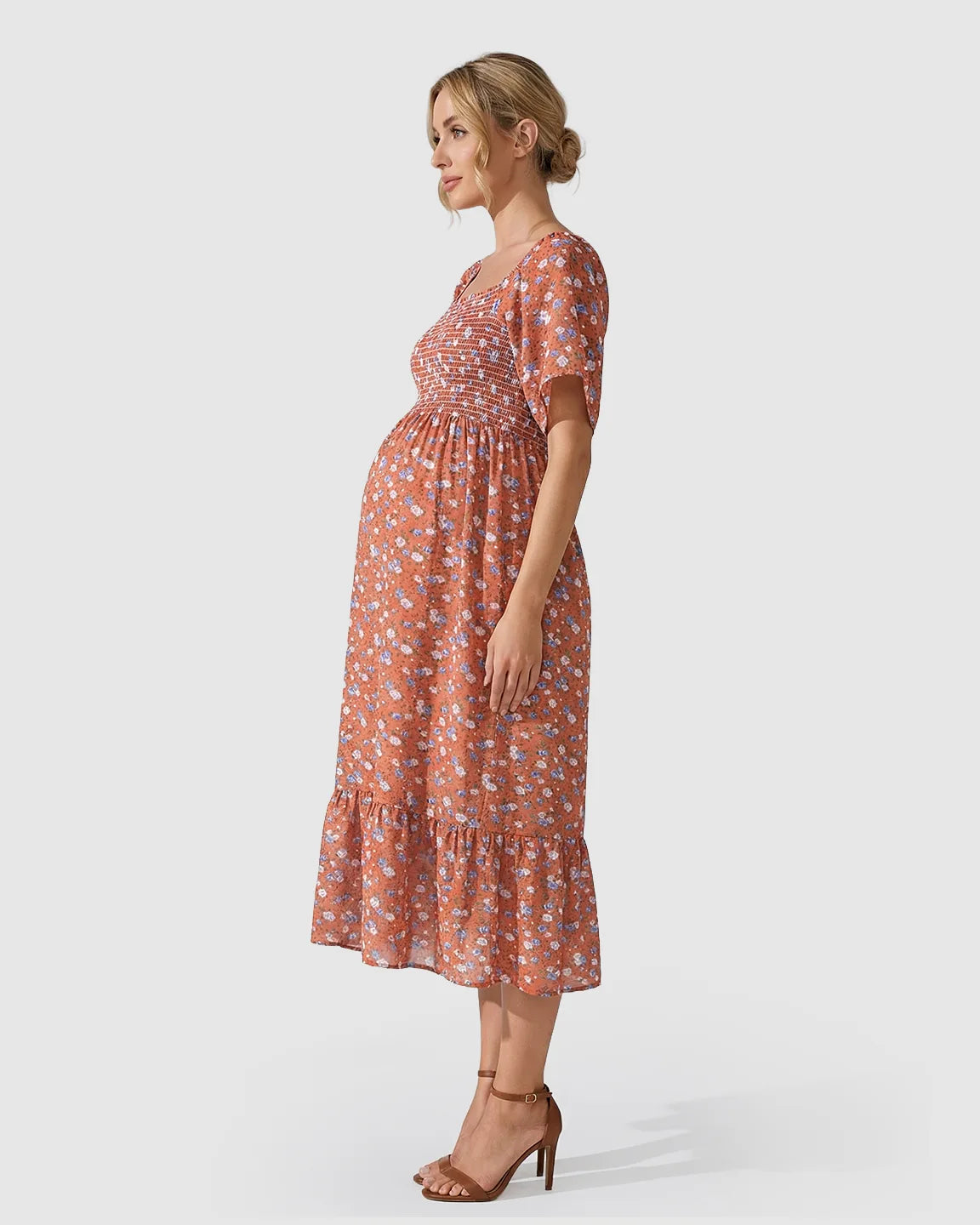 Maternity midi dress in rust with blue floral print, smocked bodice, flutter sleeves, and tiered skirt.