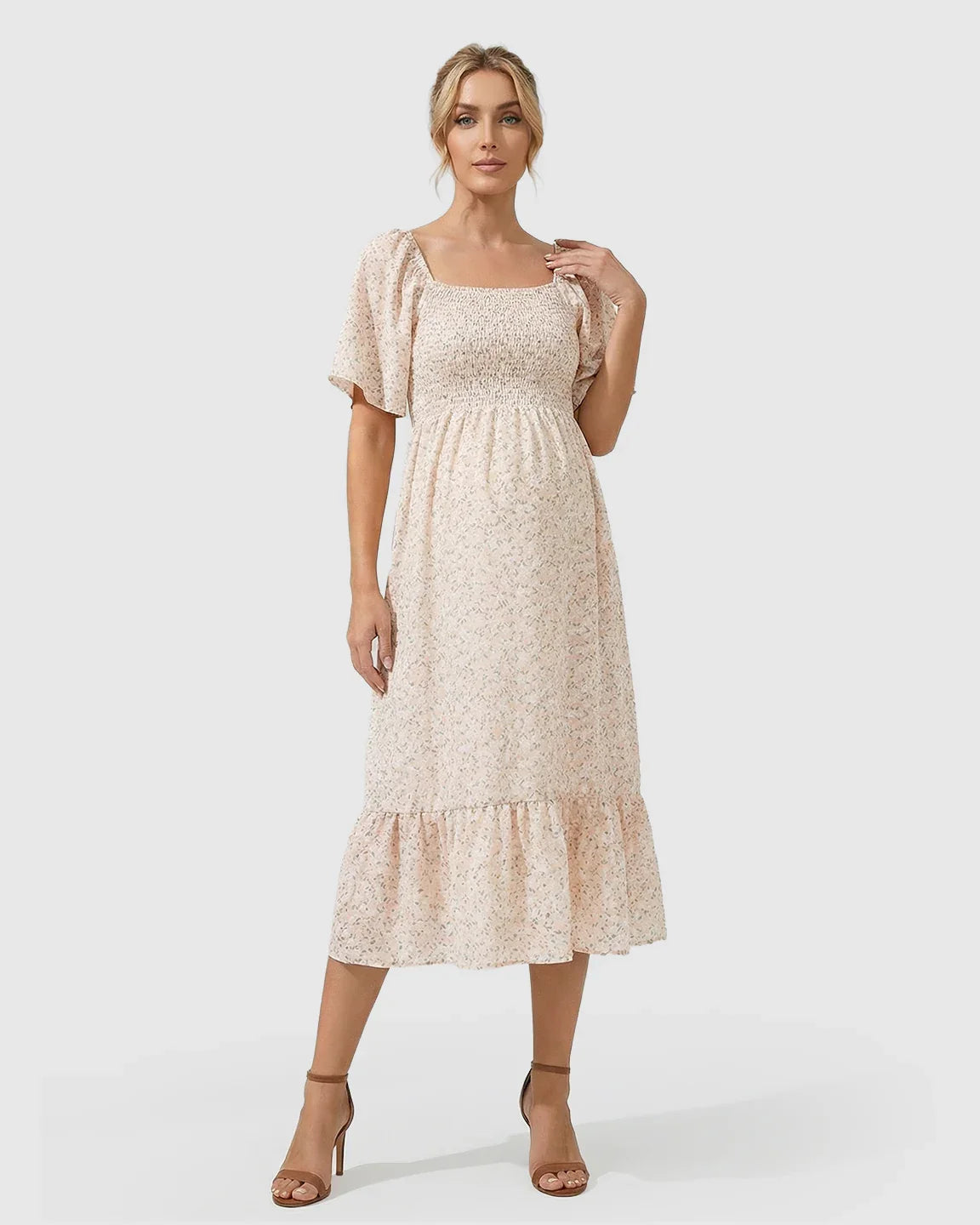 Light pink floral flutter-sleeve smocked maternity midi dress with tiered skirt.