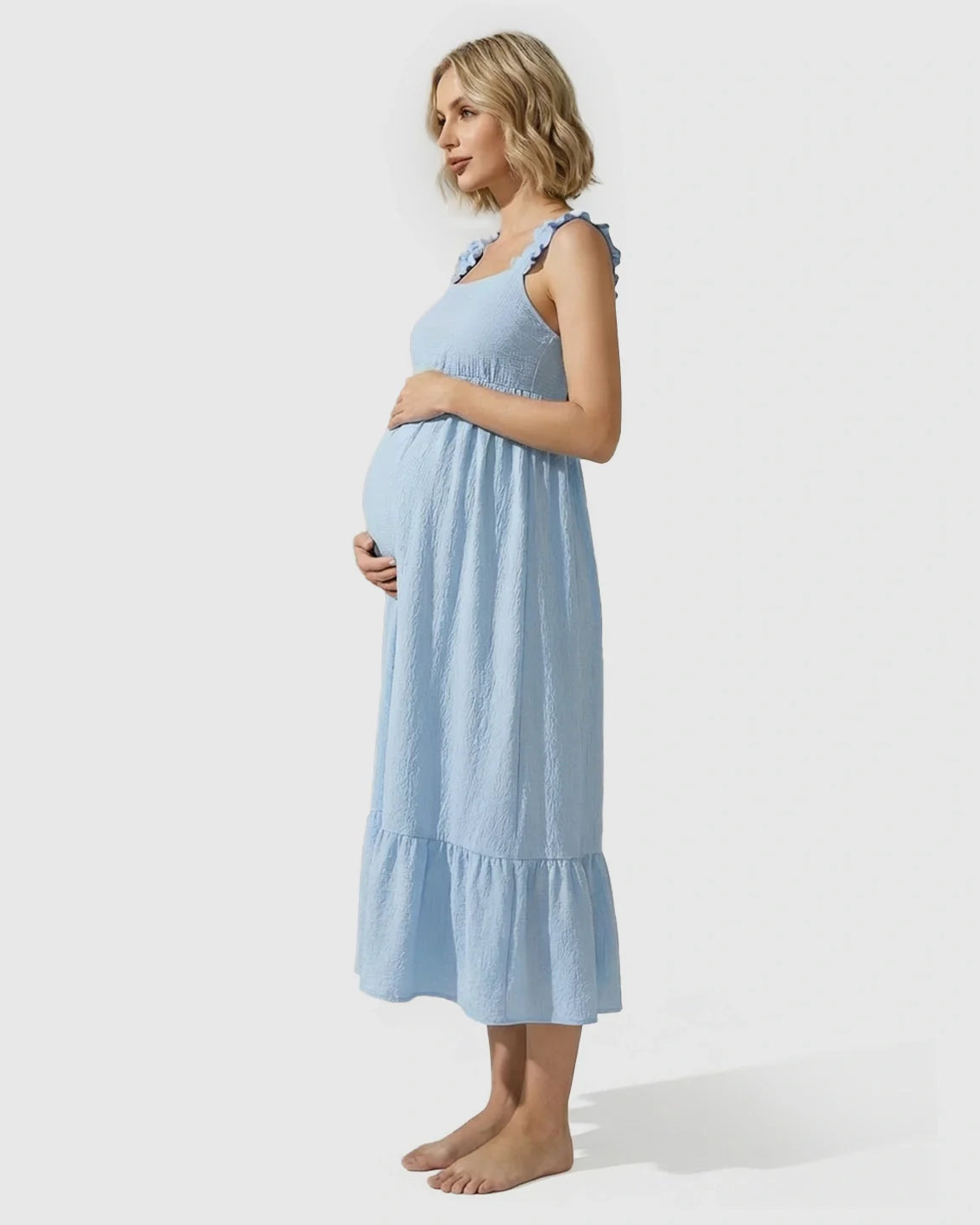 Pregnant woman in a light blue tiered maxi dress with ruffled straps and empire waist.