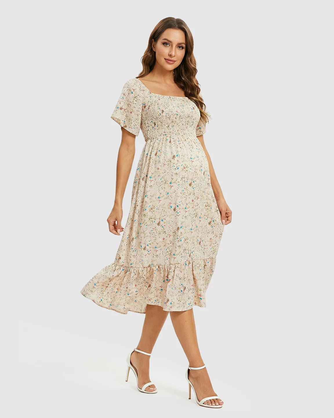 Flutter-sleeve smocked maternity midi dress in light beige with a colorful floral print and tiered skirt.