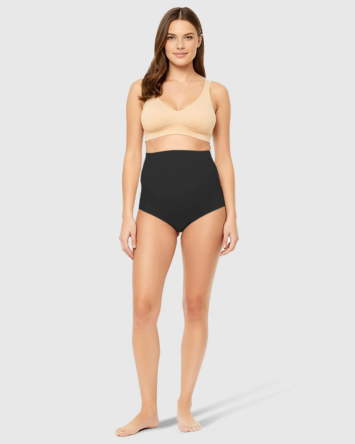 Woman in black high-waist seamless belly-support maternity underwear and a nude bra.