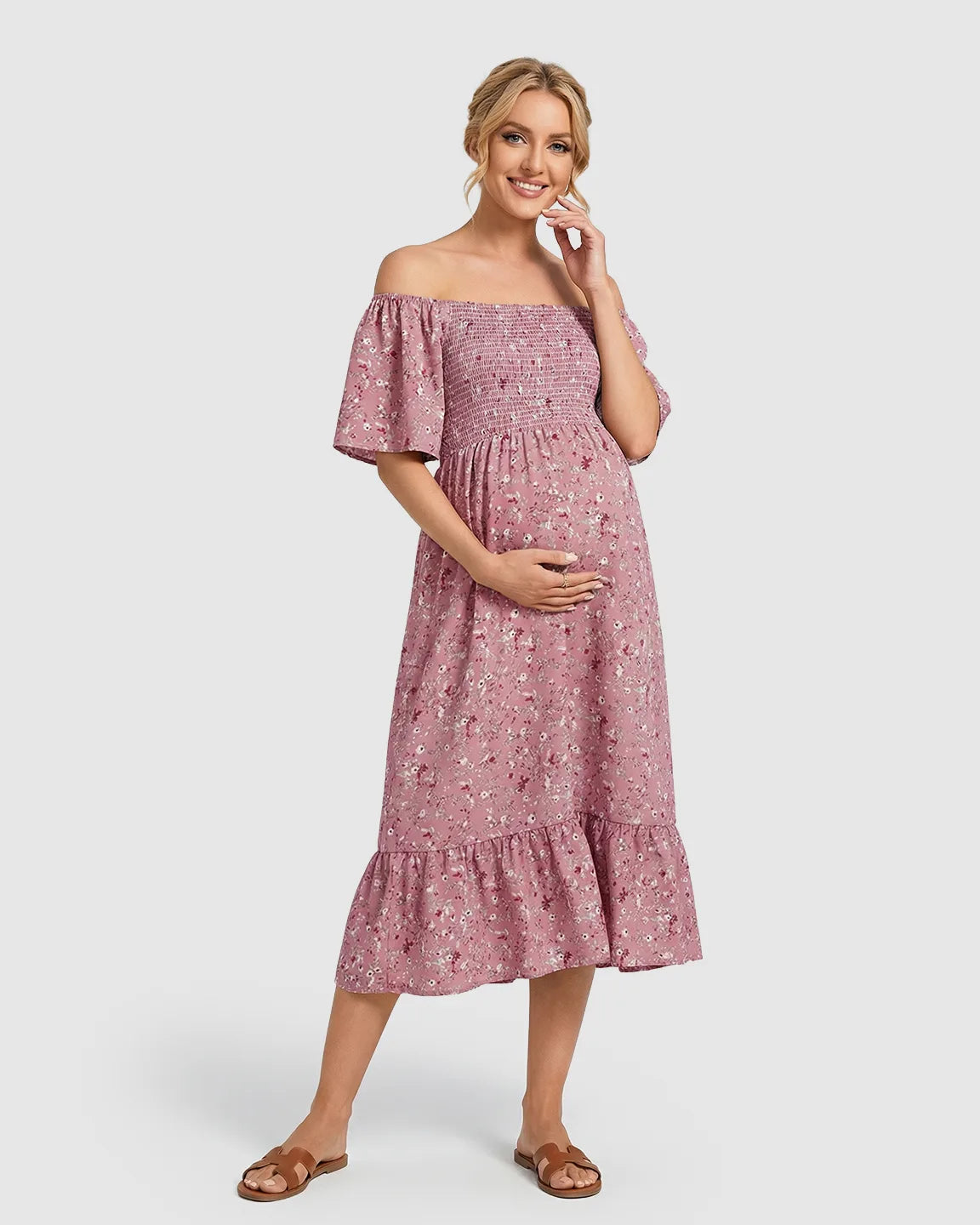 Pink floral off-shoulder smocked maternity midi dress with flutter sleeves and tiered skirt.