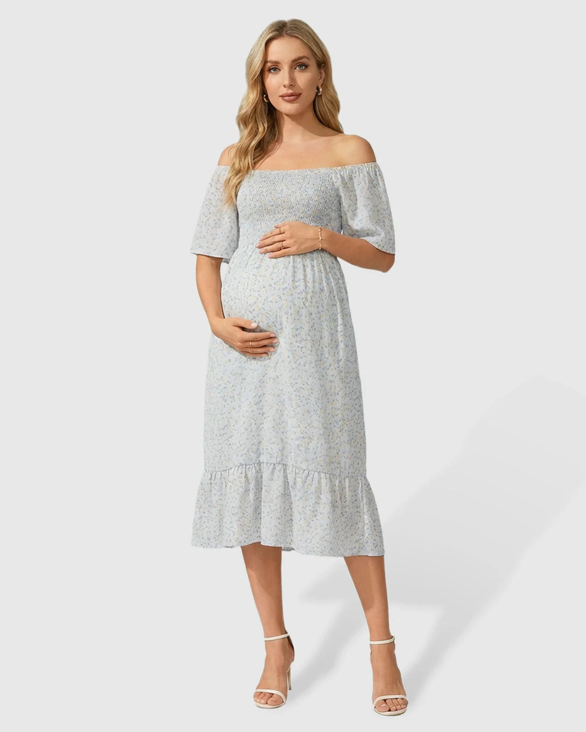 Pregnant woman in light blue floral off-shoulder smocked midi dress with flutter sleeves and tiered skirt.