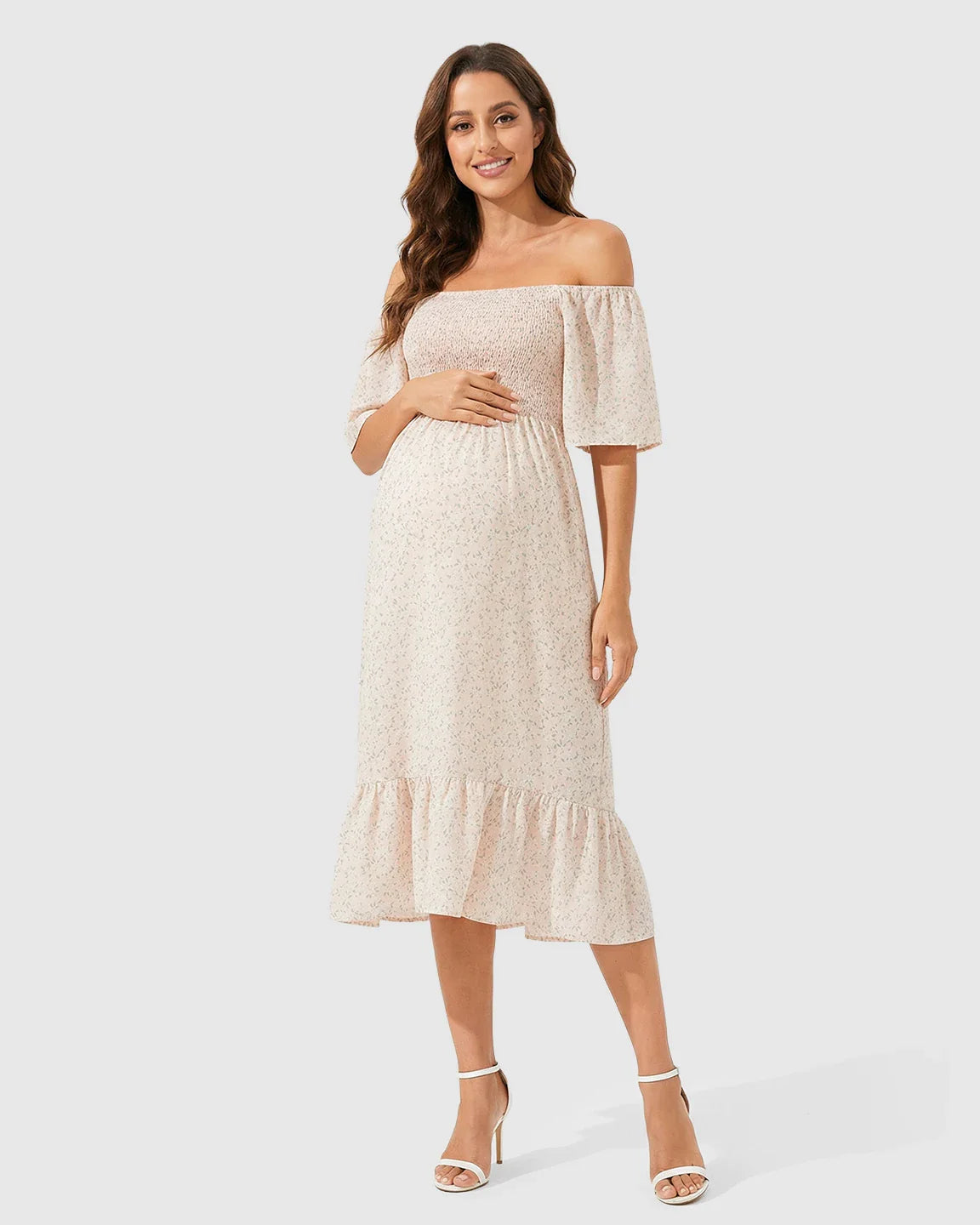 Maternity midi dress with off-shoulder smocked top, flutter sleeves, and floral print.