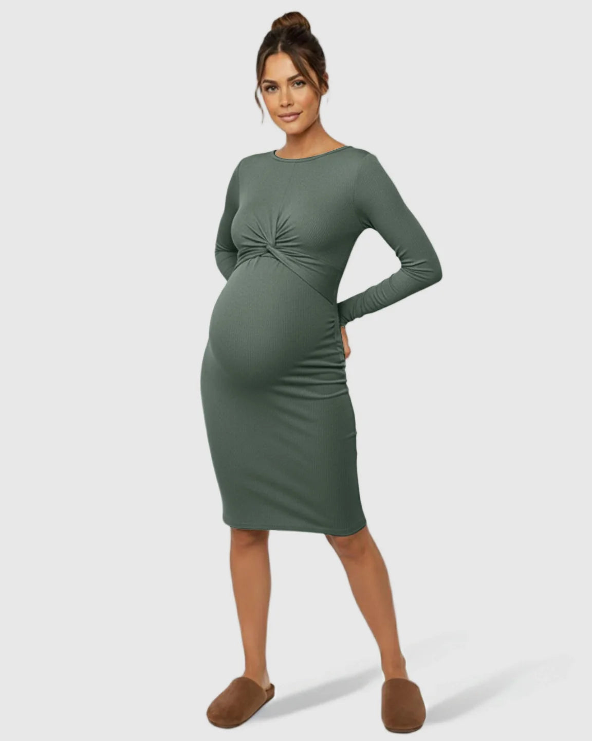 Maternity model in a long-sleeve, olive green ribbed bodycon dress with a twist-front detail, highlighting her bump.