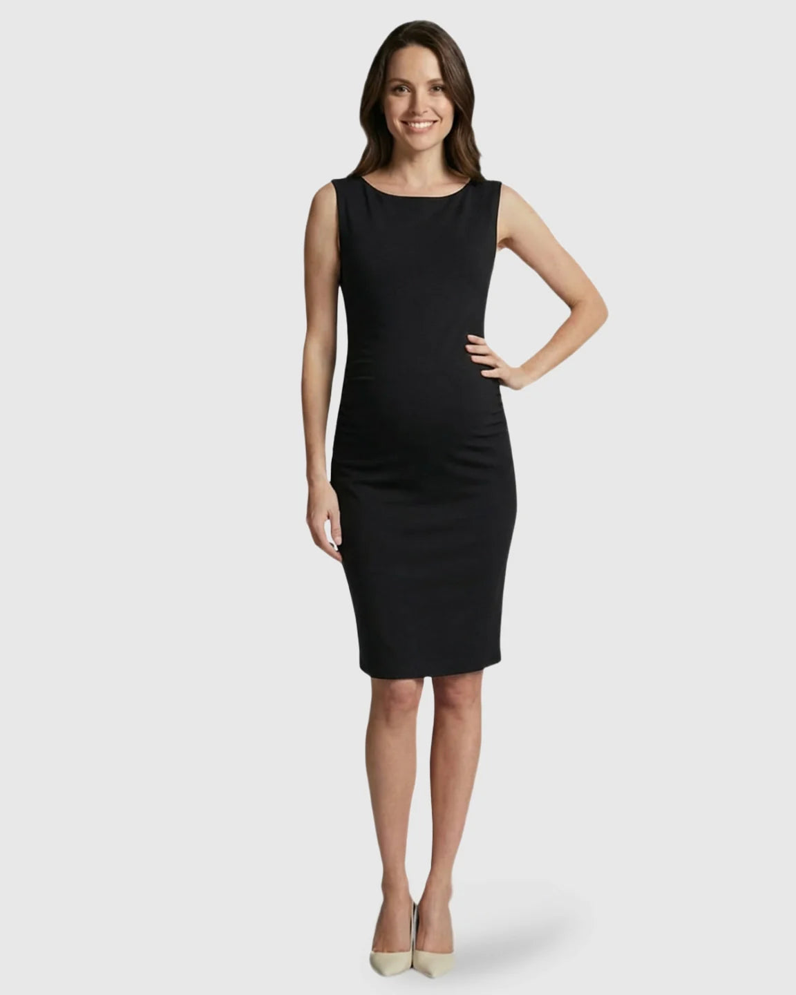Smiling pregnant woman in a black sleeveless bodycon maternity midi dress with a boat neck.