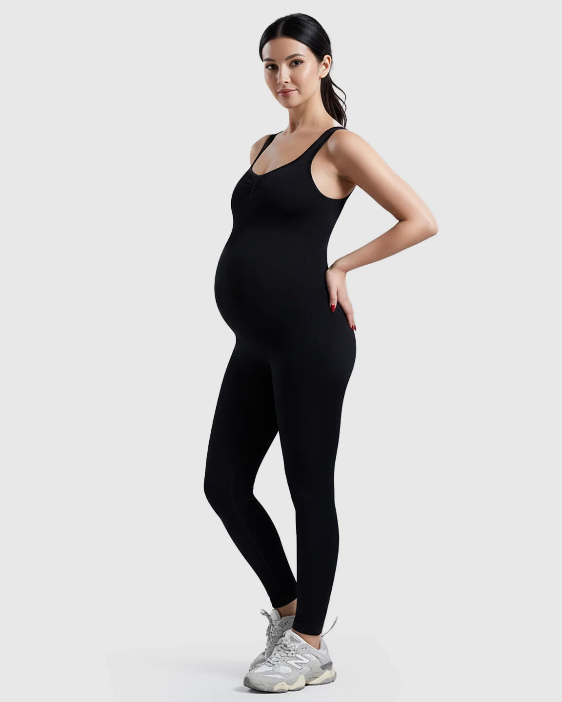 Black ribbed high-waisted maternity bodysuit with spaghetti straps, worn by a pregnant woman.