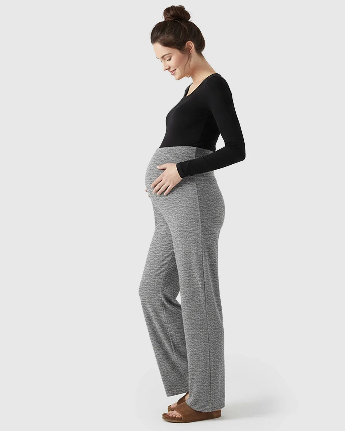 Pregnant woman in gray fleece relaxed maternity pants with over-belly waistband and wide-leg silhouette.