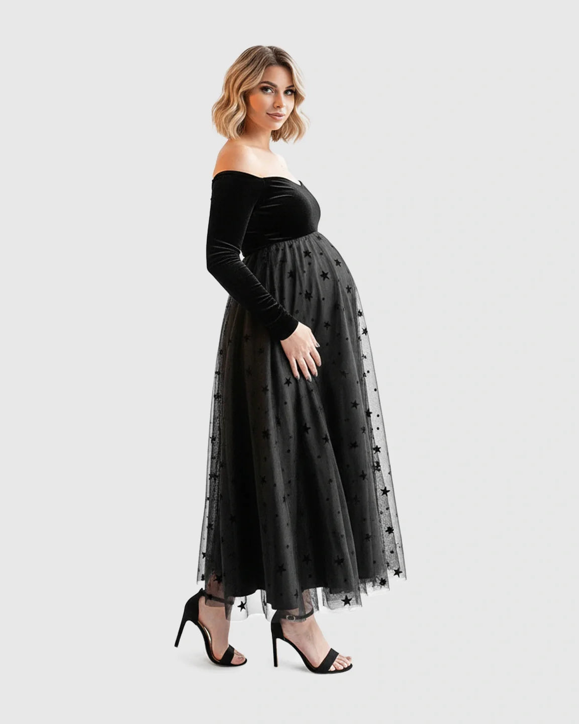 Black off-shoulder velvet bodice maternity midi dress with a star-flocked mesh skirt.