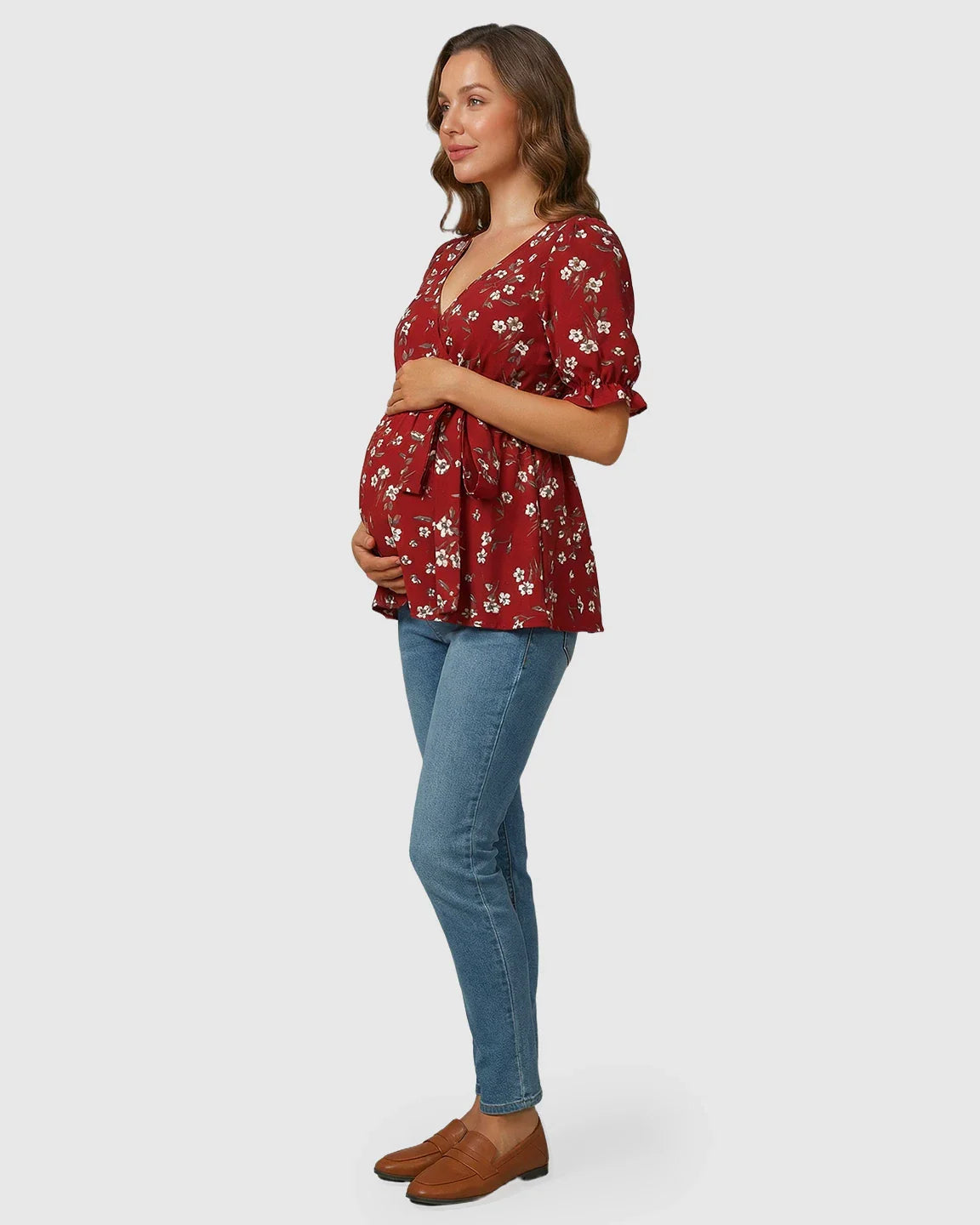 Red floral crossover V-neck maternity & nursing top with puff sleeves and tie waist, worn by a pregnant woman.