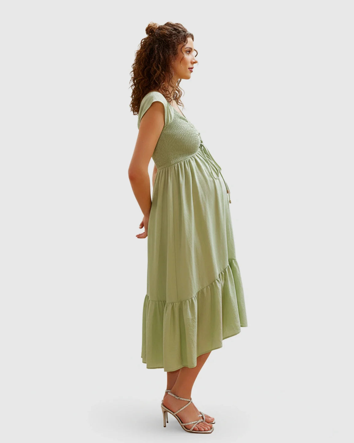 Maternity midi dress in light green with smocked bodice, adjustable drawstring, cap sleeves, and flowy skirt.