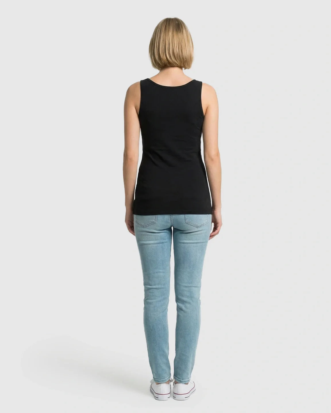 Woman from behind wearing a black stretch nursing-access maternity tank top and light blue jeans.