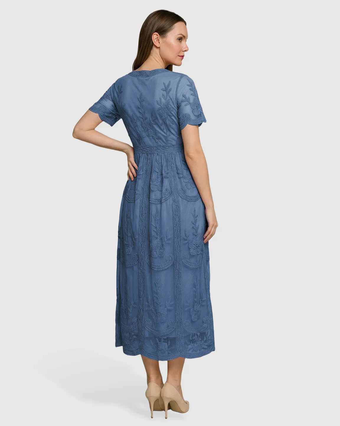 Woman in a blue lace maternity midi dress with V-neck, short sleeves, and swing skirt, posing from behind.