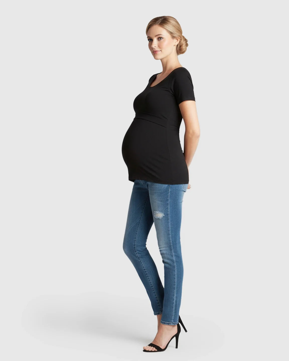 Pregnant woman in a black stretch-fit V-neck nursing t-shirt and jeans.