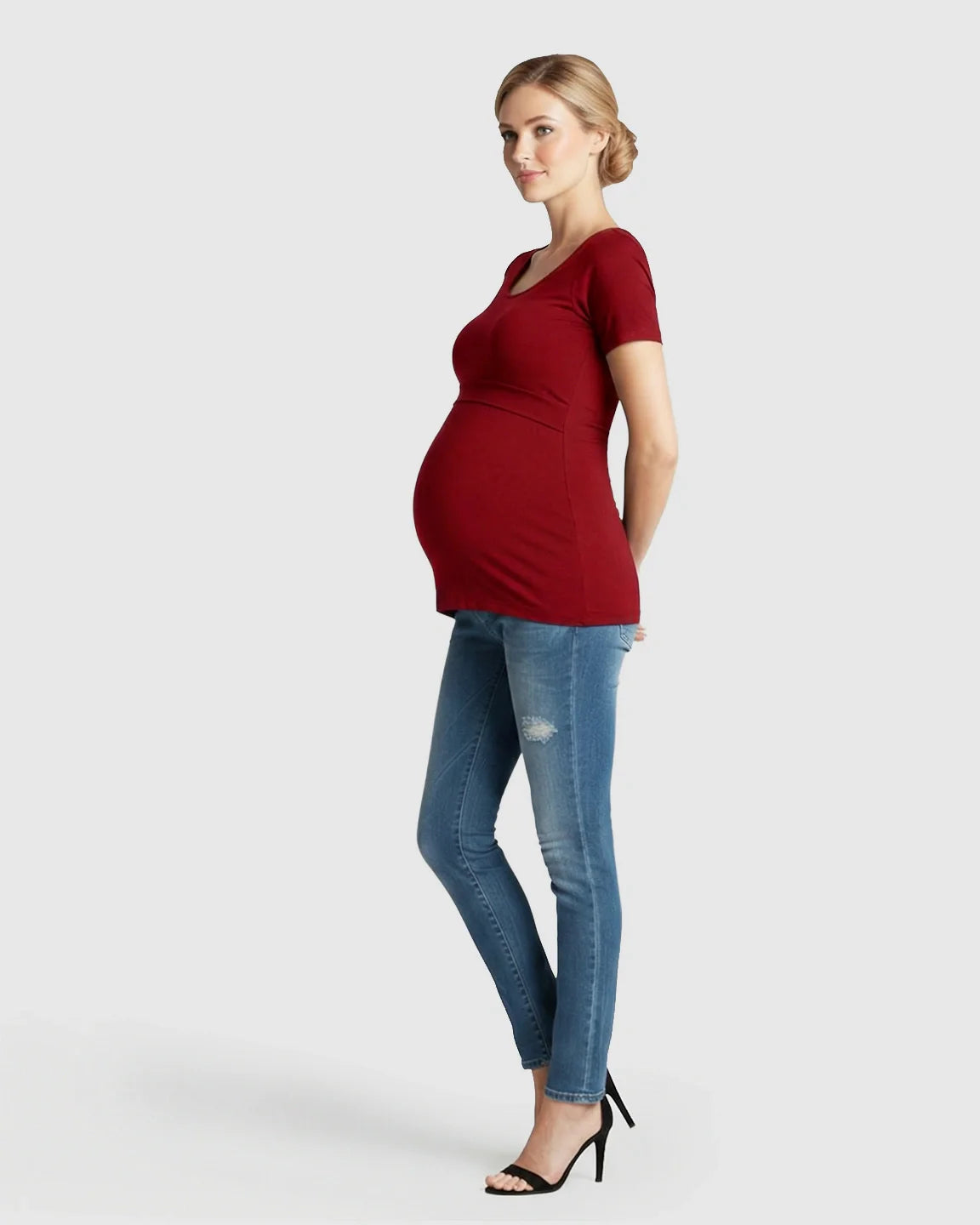 Pregnant woman in a red stretch-fit V-neck nursing t-shirt and jeans.