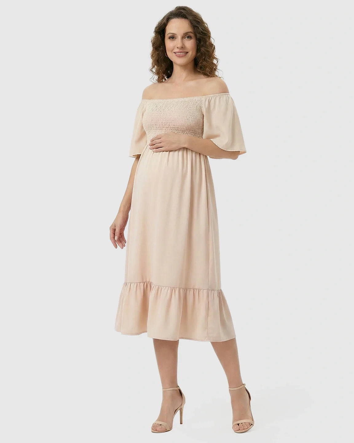 Pregnant woman in a peach flutter-sleeve smocked maternity midi dress with tiered skirt and heels.