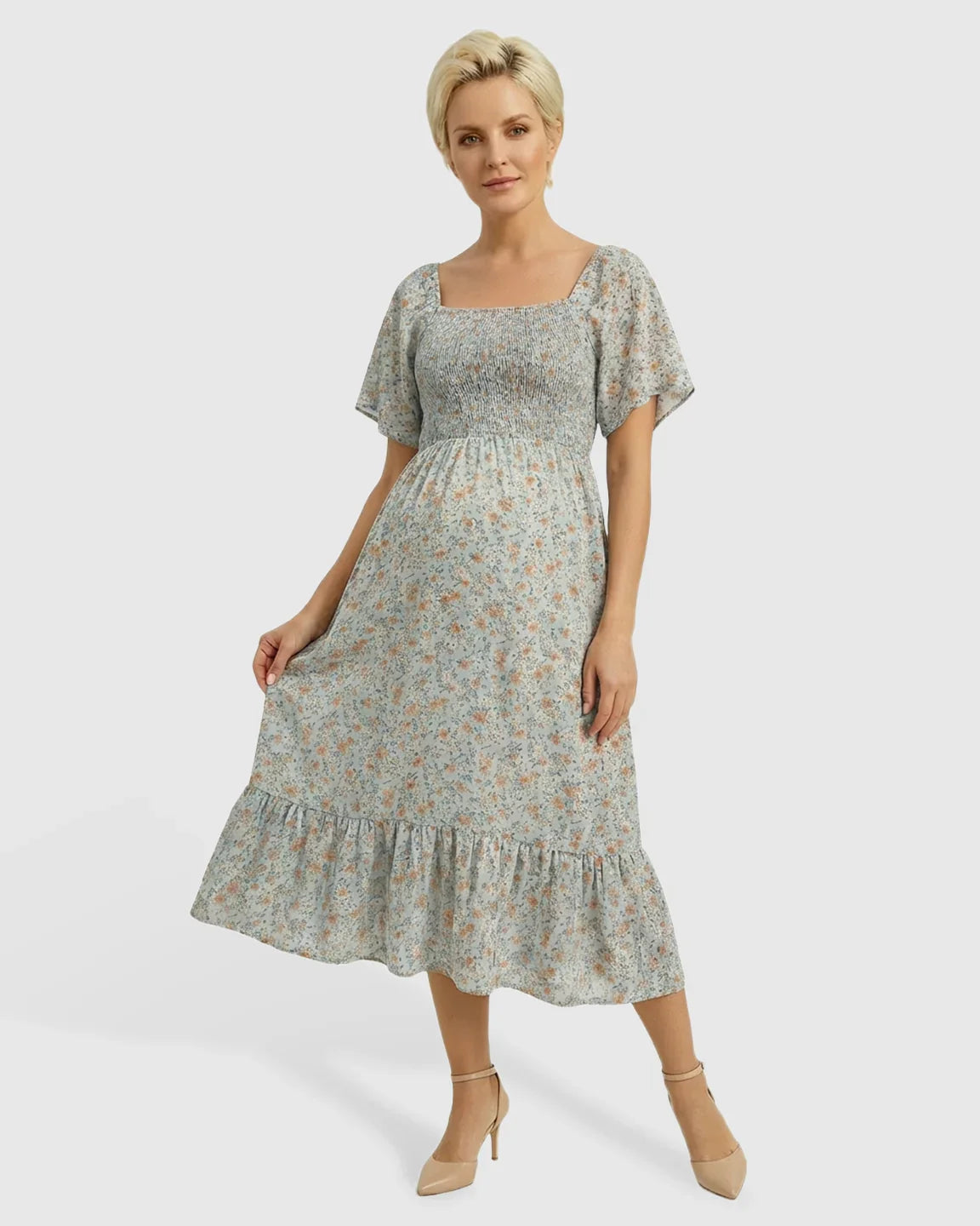 Light blue floral flutter-sleeve smocked maternity midi dress with tiered skirt.