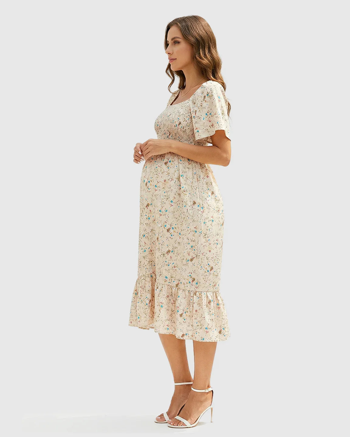 Maternity midi dress in light beige with blue floral print, flutter sleeves, and smocked bodice.