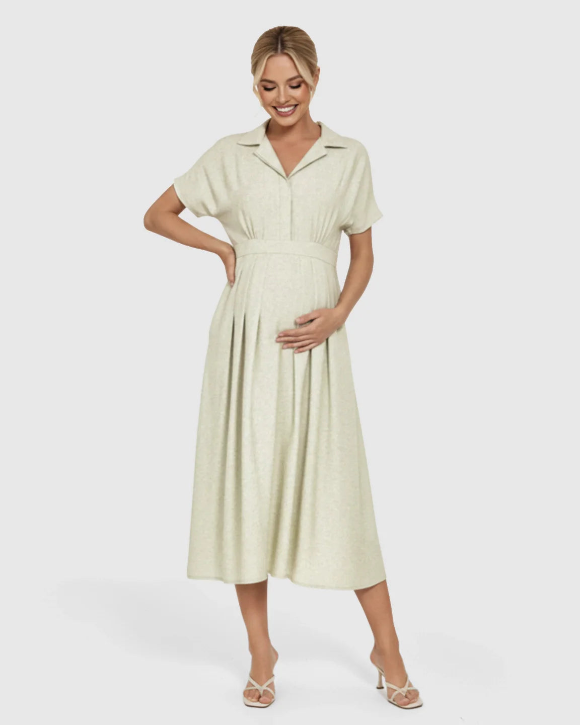 Smiling pregnant woman in a light green lapel collar A-line maternity midi dress with a belted waist.