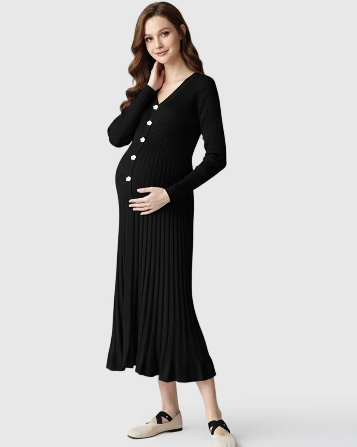 Pregnant woman in a black ribbed knit maternity midi dress with long sleeves, V-neck, and white floral buttons.