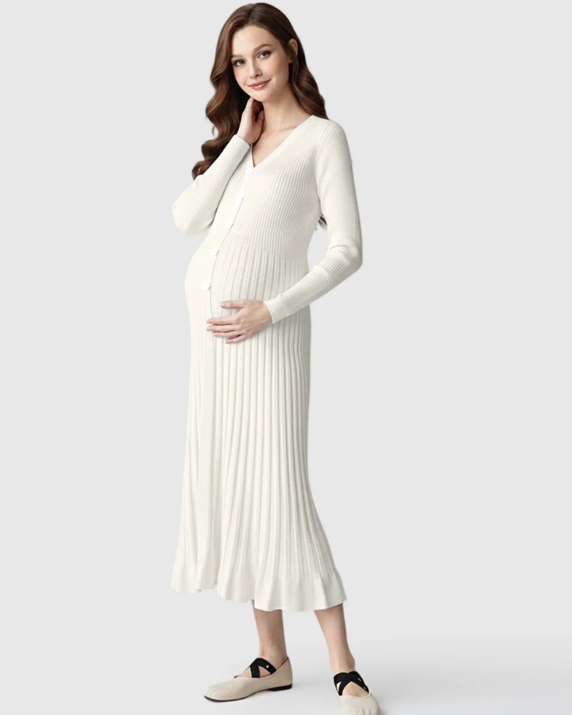 Pregnant woman in a white ribbed knit maternity midi dress with long sleeves, V-neck, and front buttons.