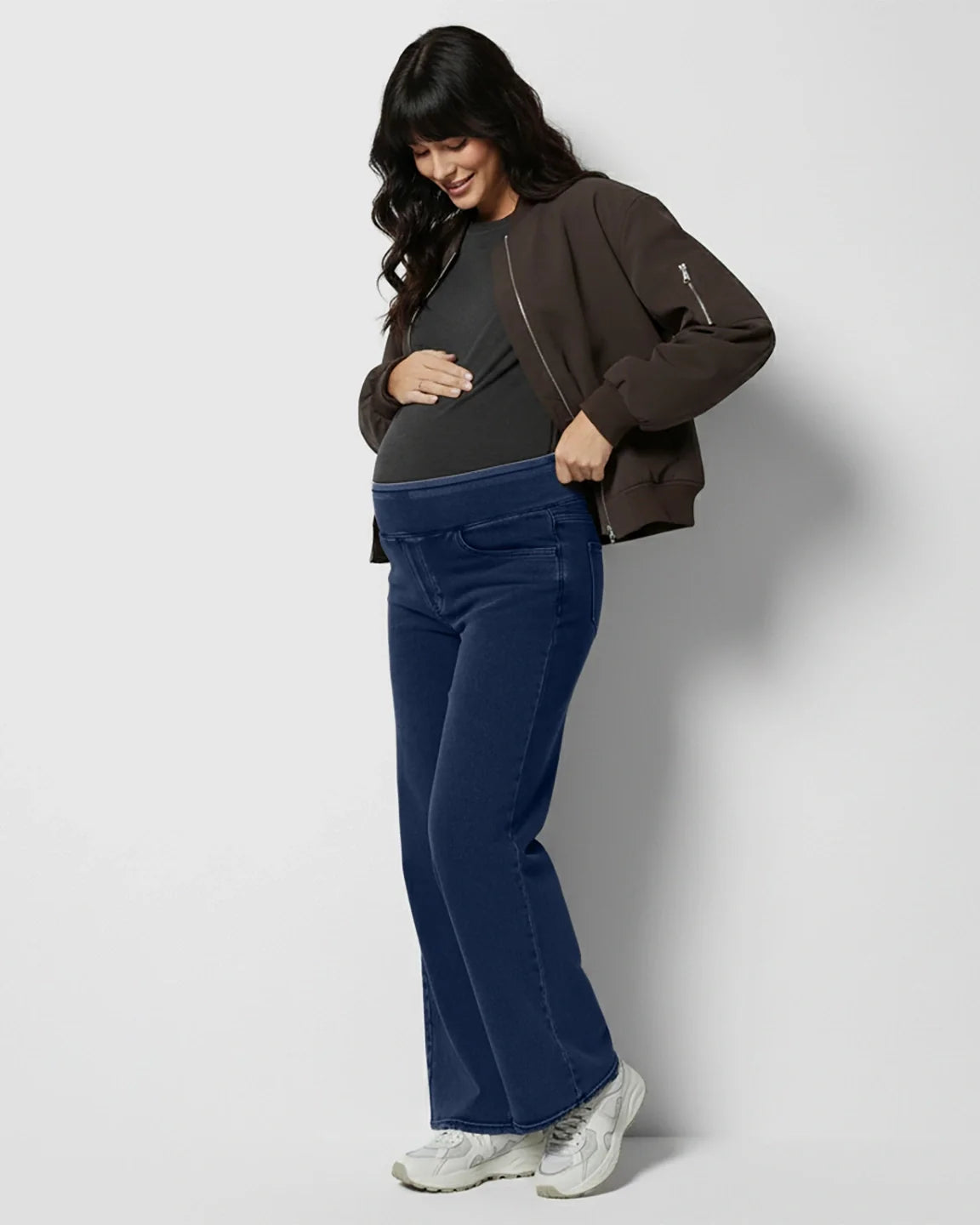Pregnant woman in dark wash, high-waist wide-leg maternity denim jeans with a soft, stretchy waistband.