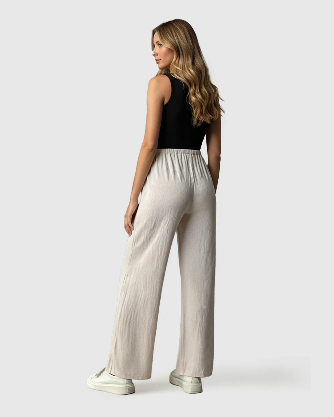 Woman wearing Bump Society beige elastic waist wide-leg maternity pants with a black top.