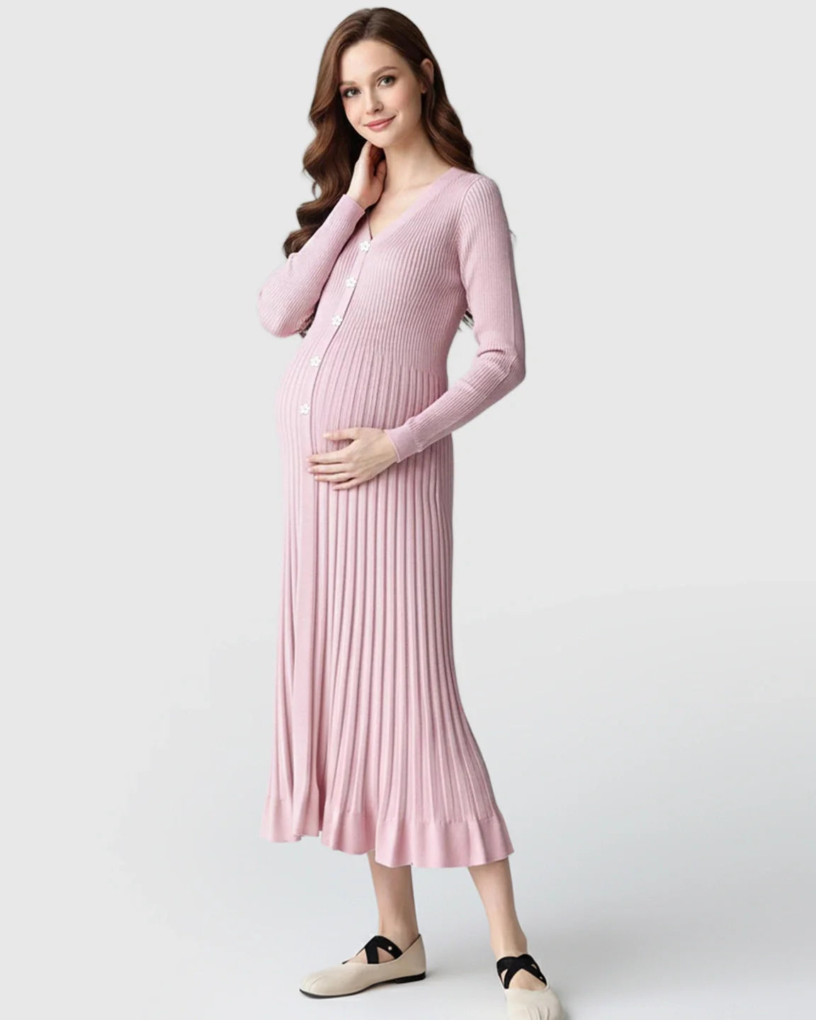 Smiling pregnant woman in a pink ribbed knit maternity midi dress with long sleeves and V-neck.