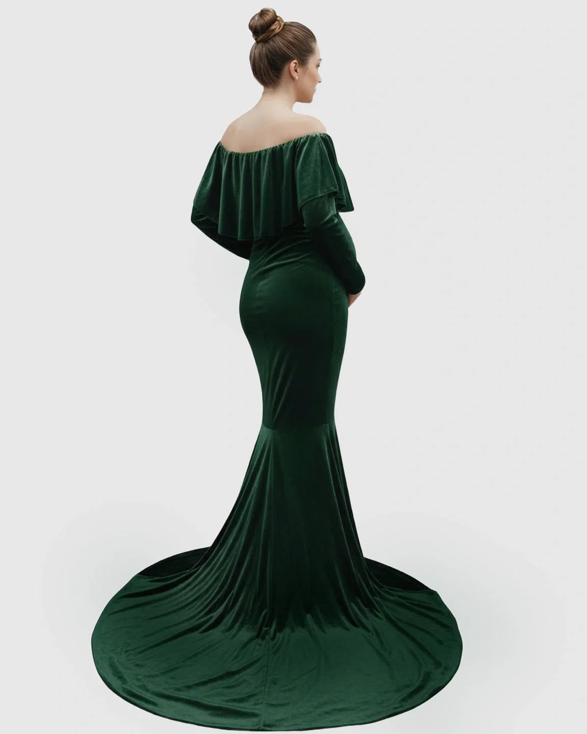 Elegant, off-shoulder emerald green velvet maternity gown with a flowing train, seen from the back.