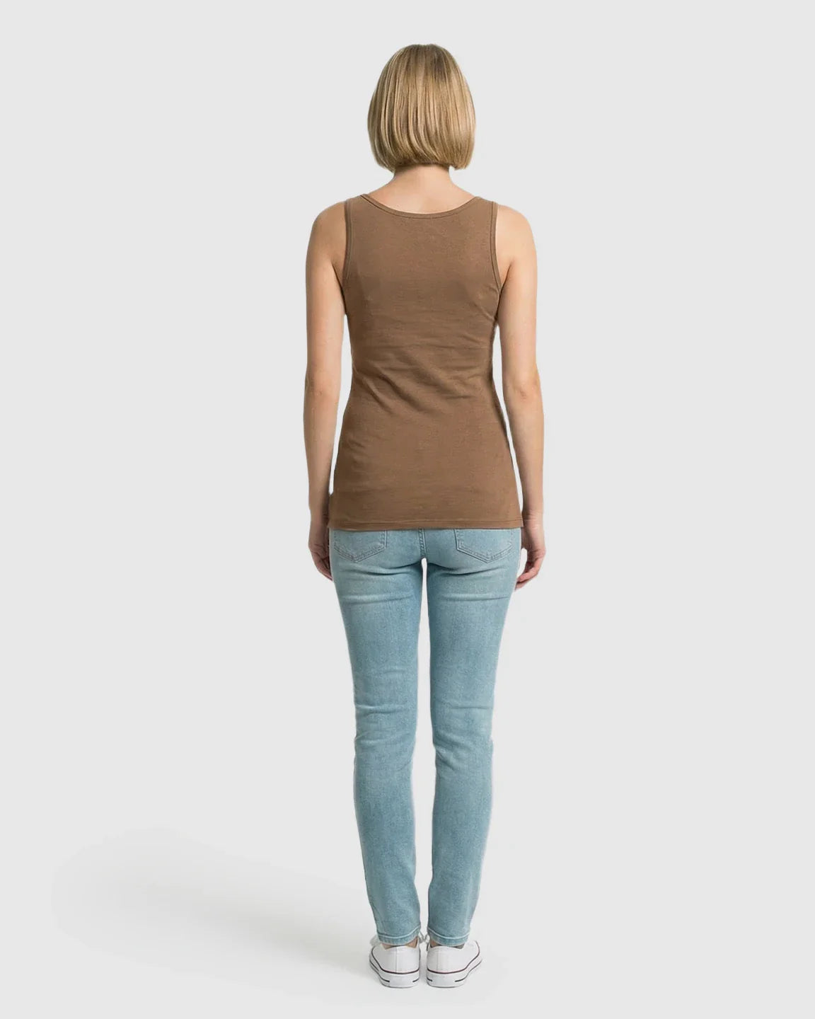 Woman from behind wearing a brown stretch nursing-access maternity tank top and light blue jeans.