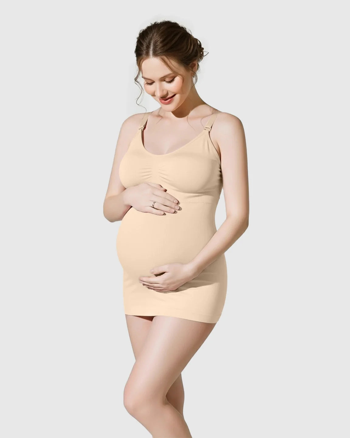 Pregnant woman in a nude soft stretch front-opening wireless maternity nursing bra camisole, holding her belly.