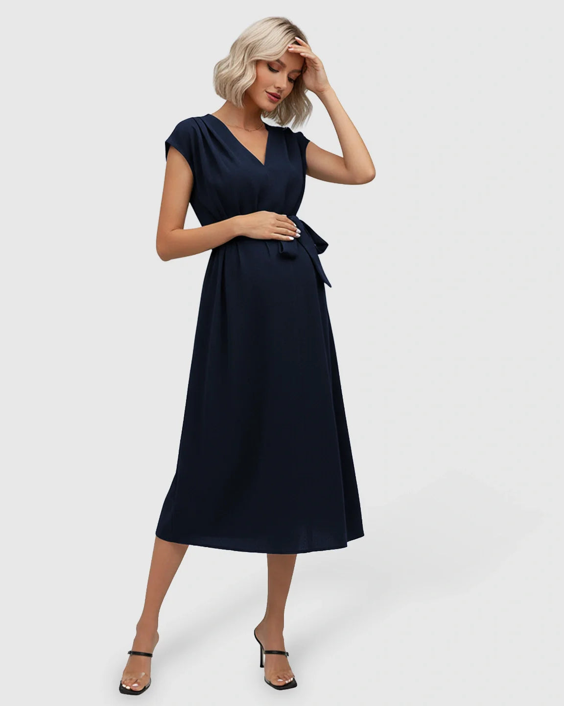 Navy tie-waist V-neck maternity midi dress with flutter sleeves, worn by a blonde model.