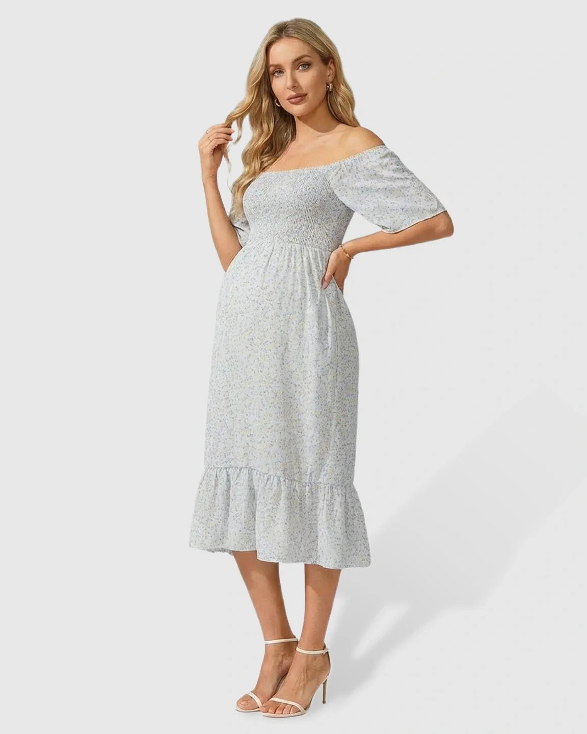 Light blue floral smocked maternity midi dress with flutter sleeves and tiered skirt.