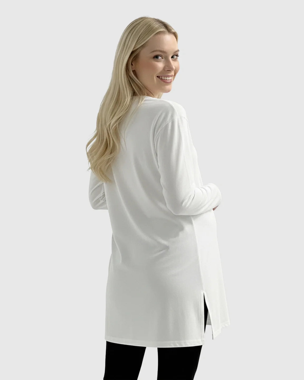 Blonde pregnant woman in a white long-sleeve, relaxed-fit cotton maternity top with side slits.