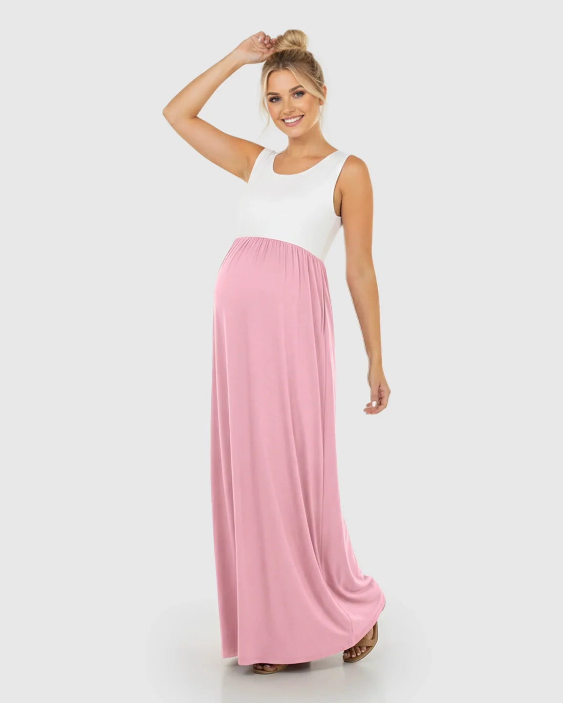 Smiling pregnant woman in a white and pink colorblock high-waisted maternity maxi dress.