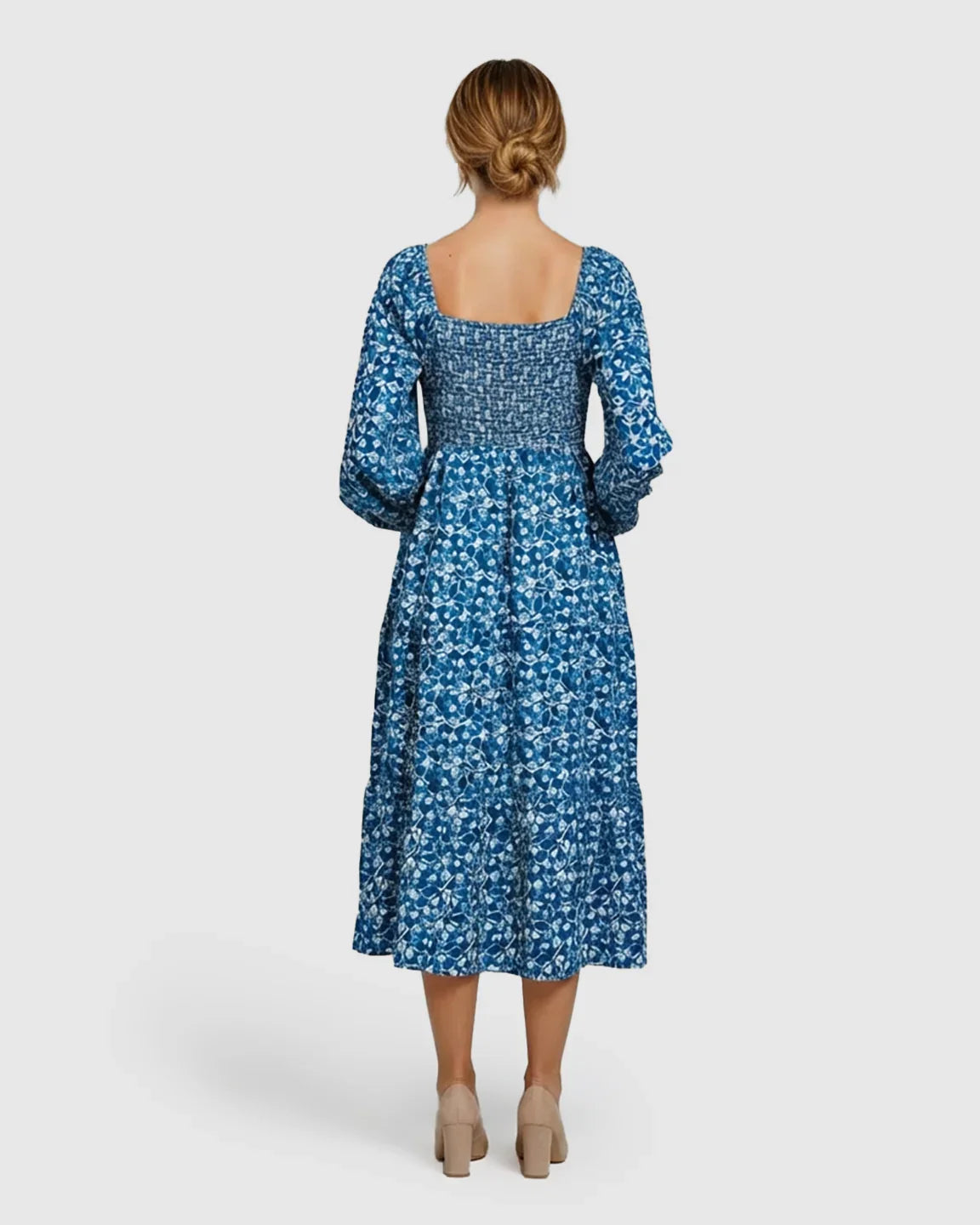 Woman in blue and white patterned A-line maternity dress with square neck, shirred bodice, and balloon sleeves.